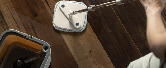 mop giratório ou linha flow sendo usado no chão de madeira escuro