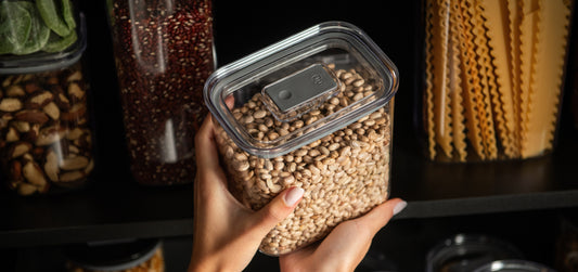 pote hermético Ou Duo Lock sendo colocado na despensa com outros potes cheios de grãos e massas