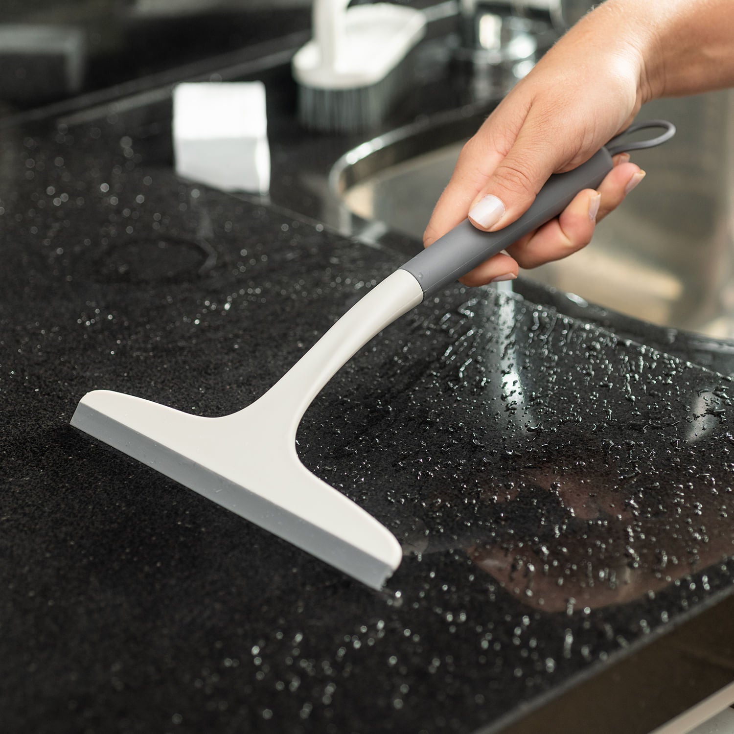 Rodo para pia da cozinha sobre a pia tirando a água