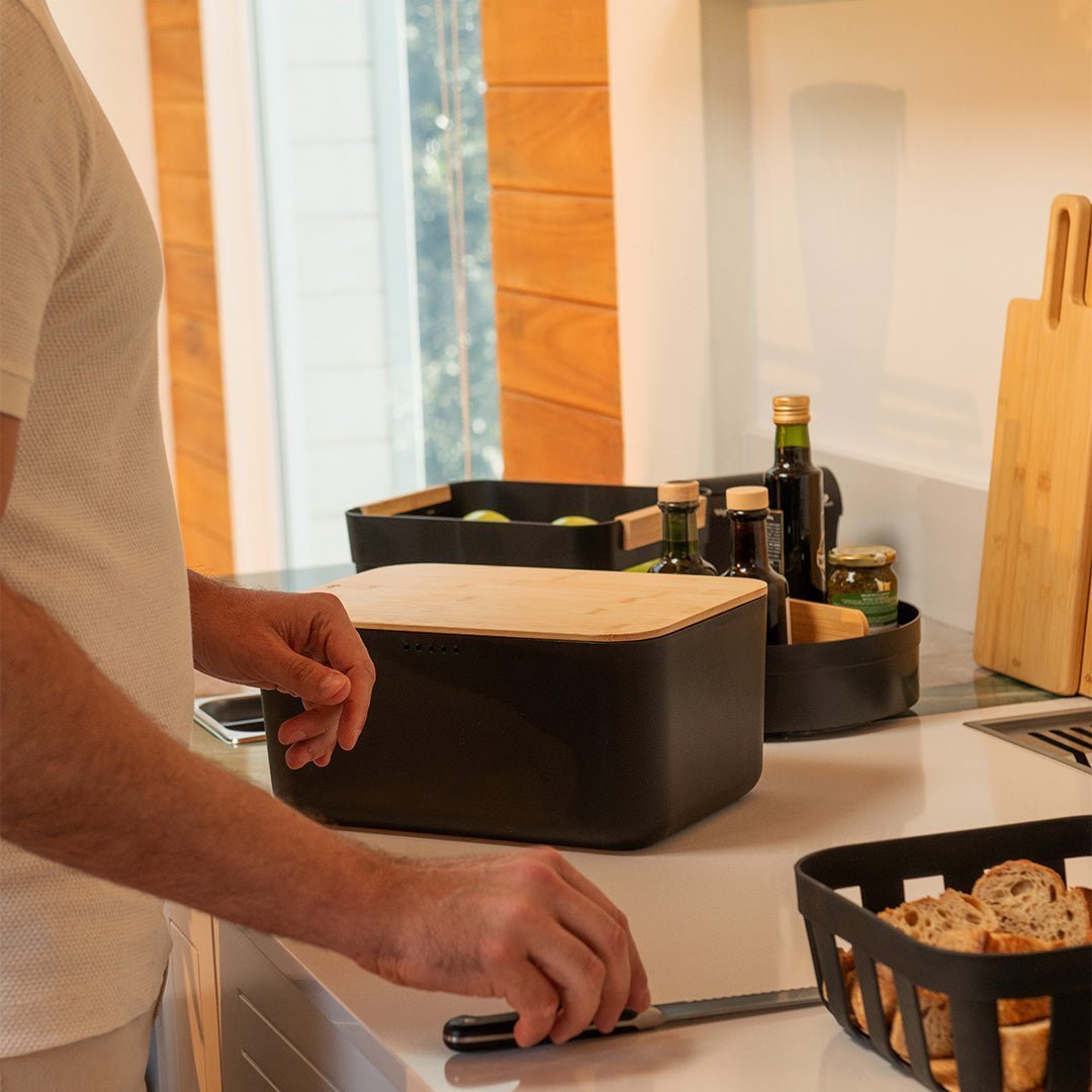 homem na bancada da cozinha com os produtos lume organizando a bancada