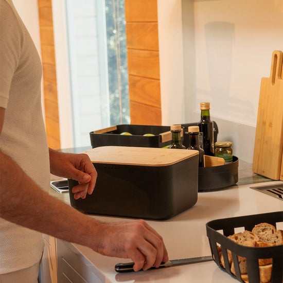 homem na bancada da cozinha com os produtos lume organizando a bancada