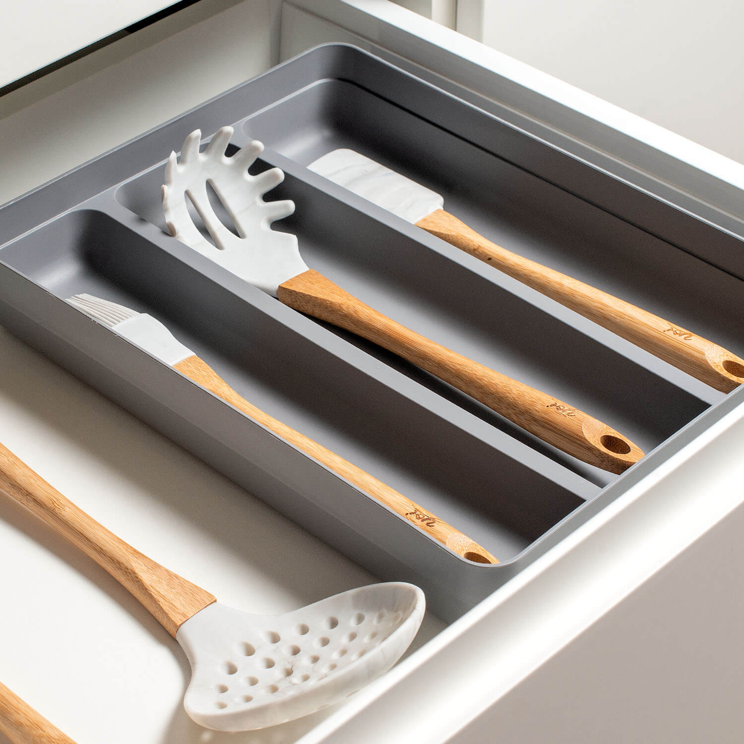 Organizador de Utensílios Logic instalado em uma gaveta e separando utensílios de cozinha